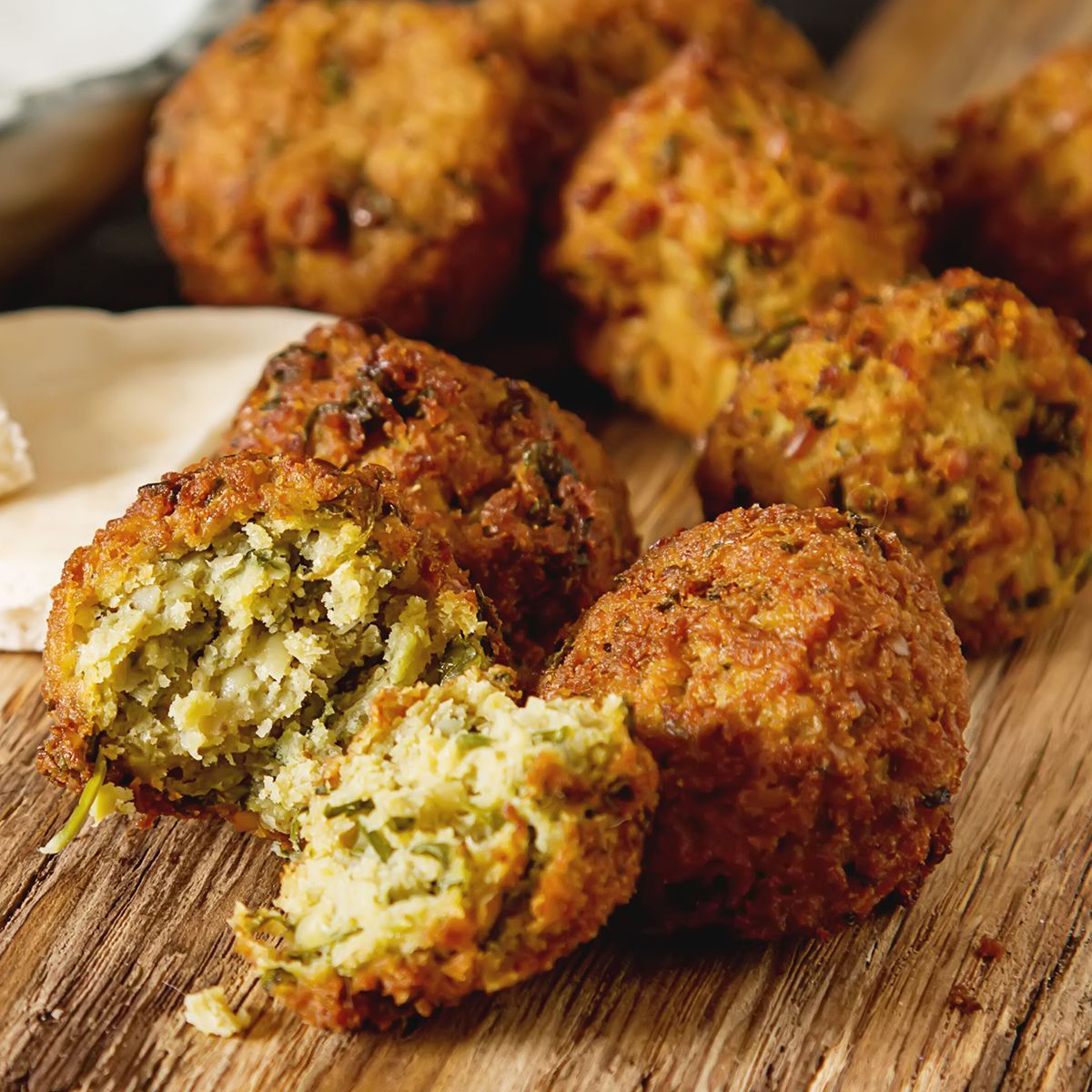a close-up of falafel balls on a wooden cutting board