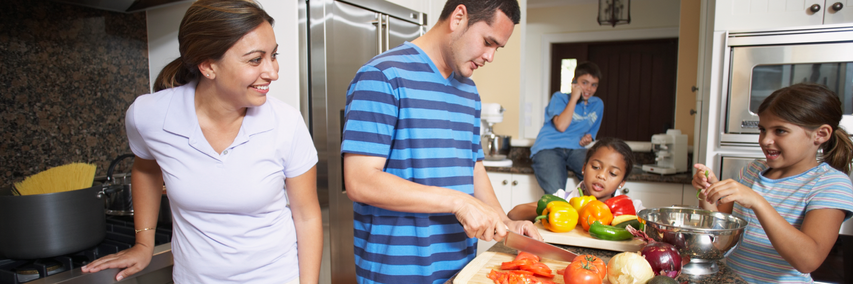 A family is preparing food together in a kitchen