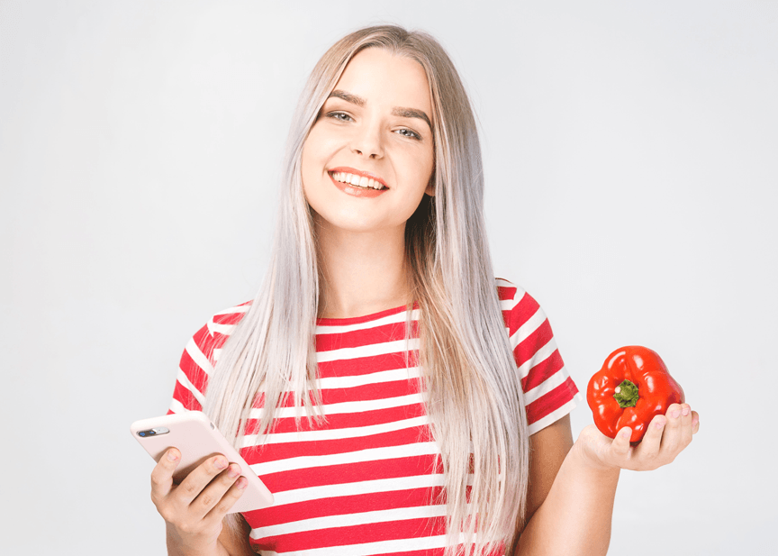 Girl holding a phone and a bell pepper