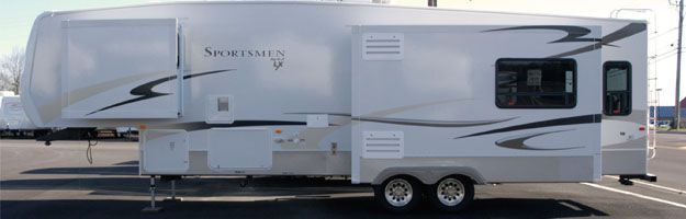 A white RV is parked in a parking lot.