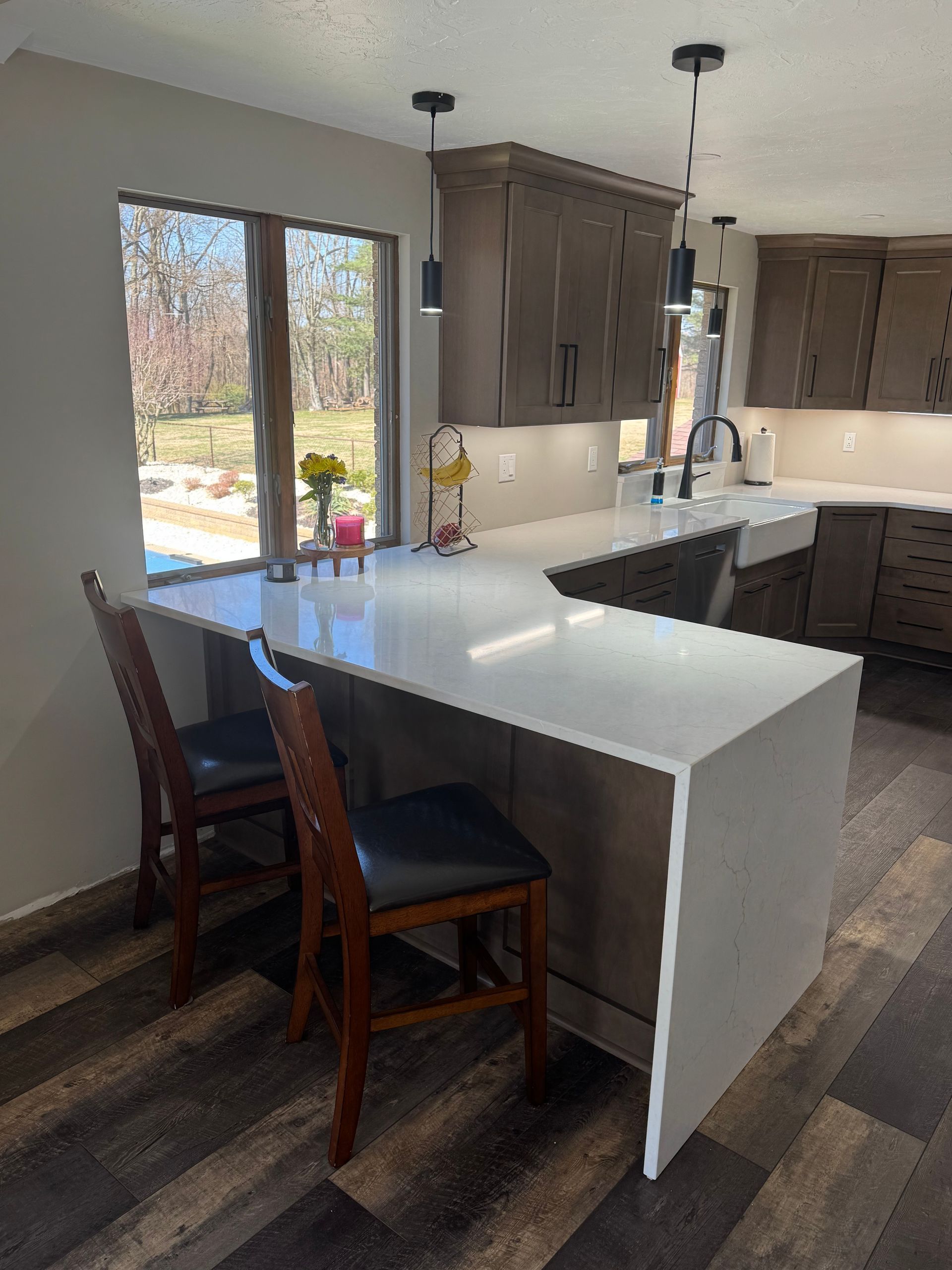 A kitchen with a large island and two chairs.