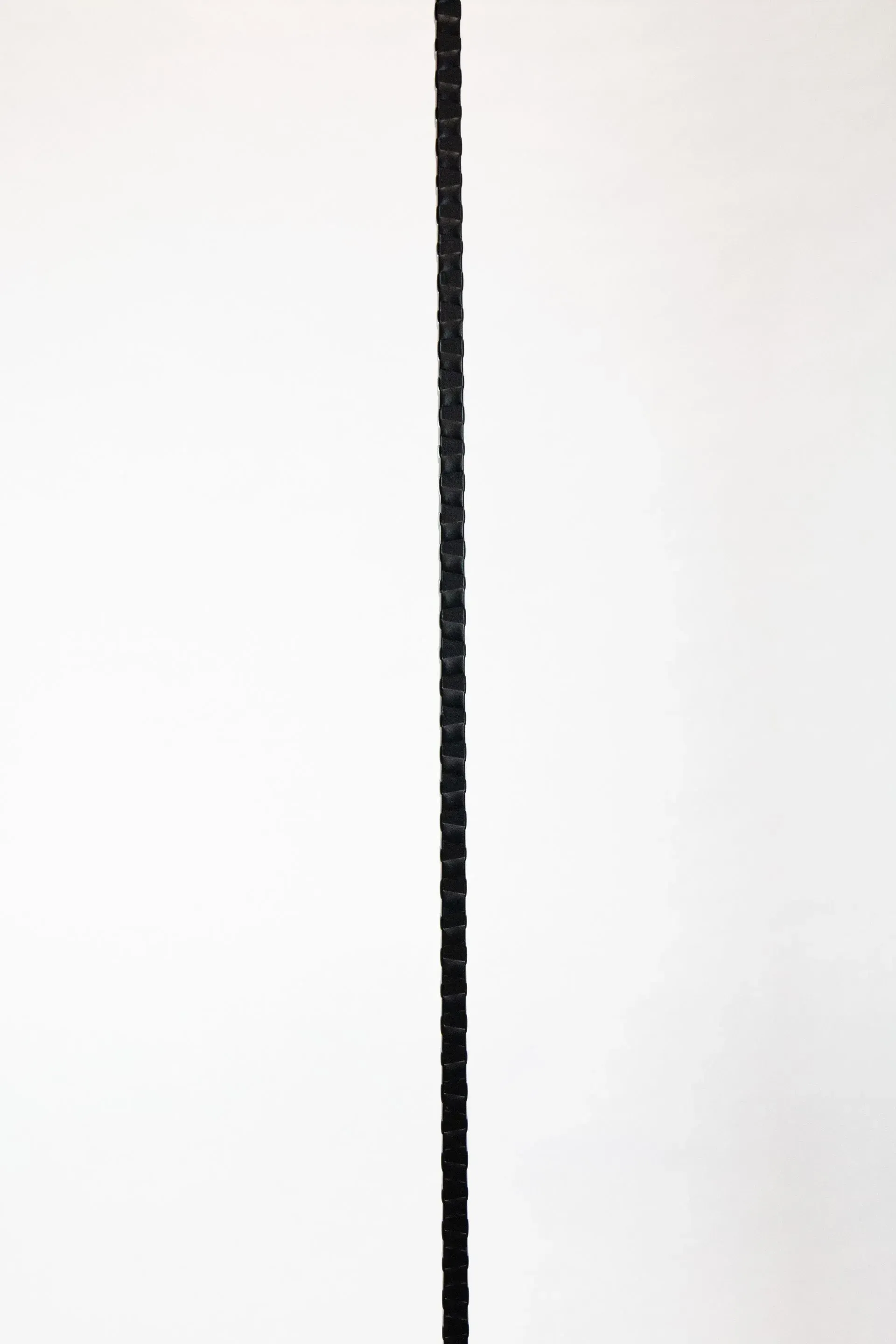 Black hacksaw blade against a white background.