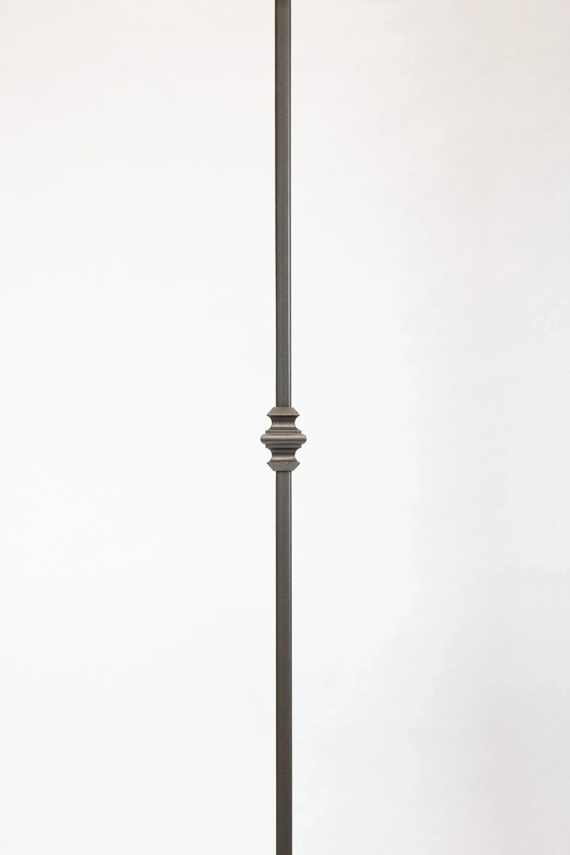 Vertical iron baluster with decorative center against a white background.