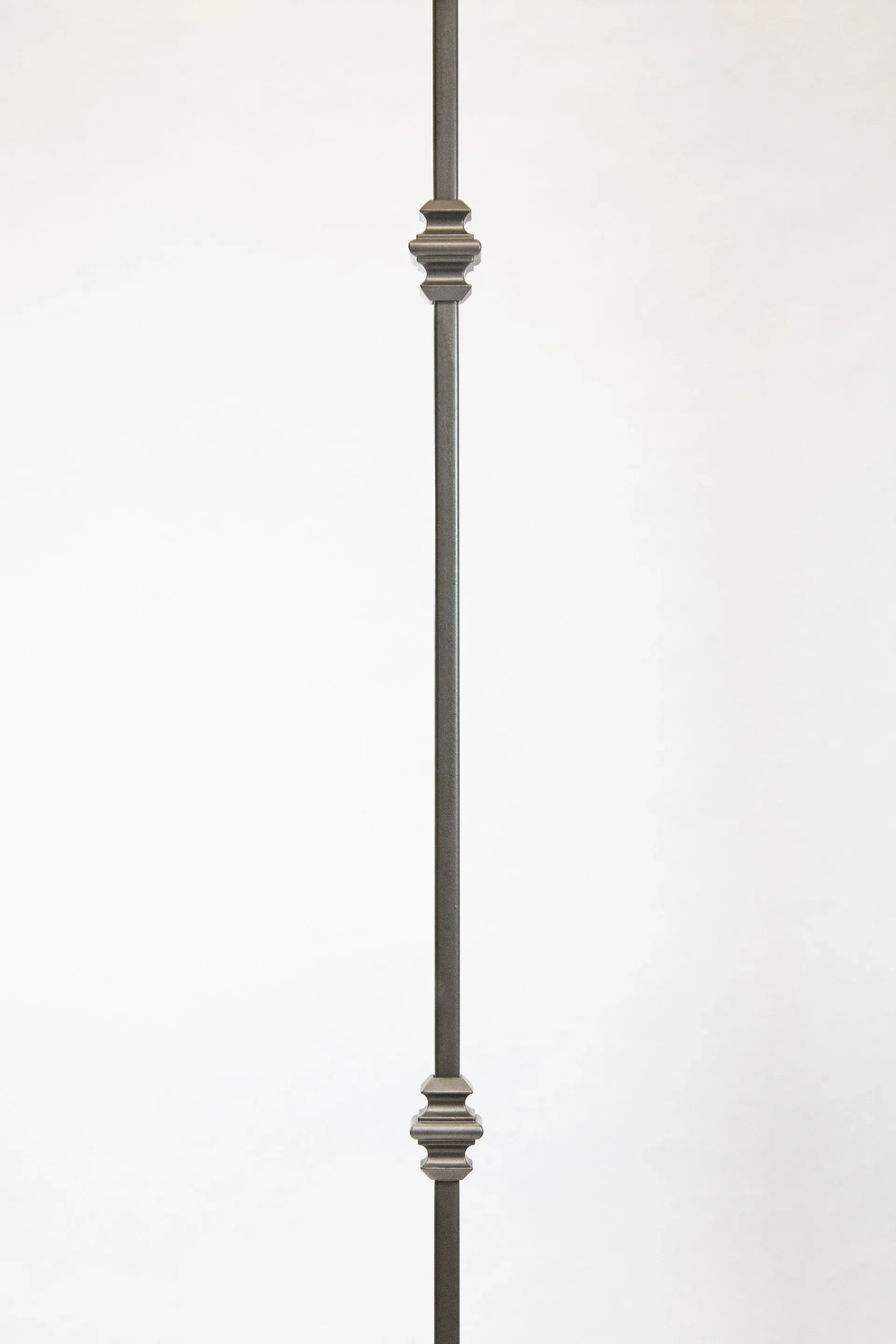Vertical metal baluster with decorative elements.