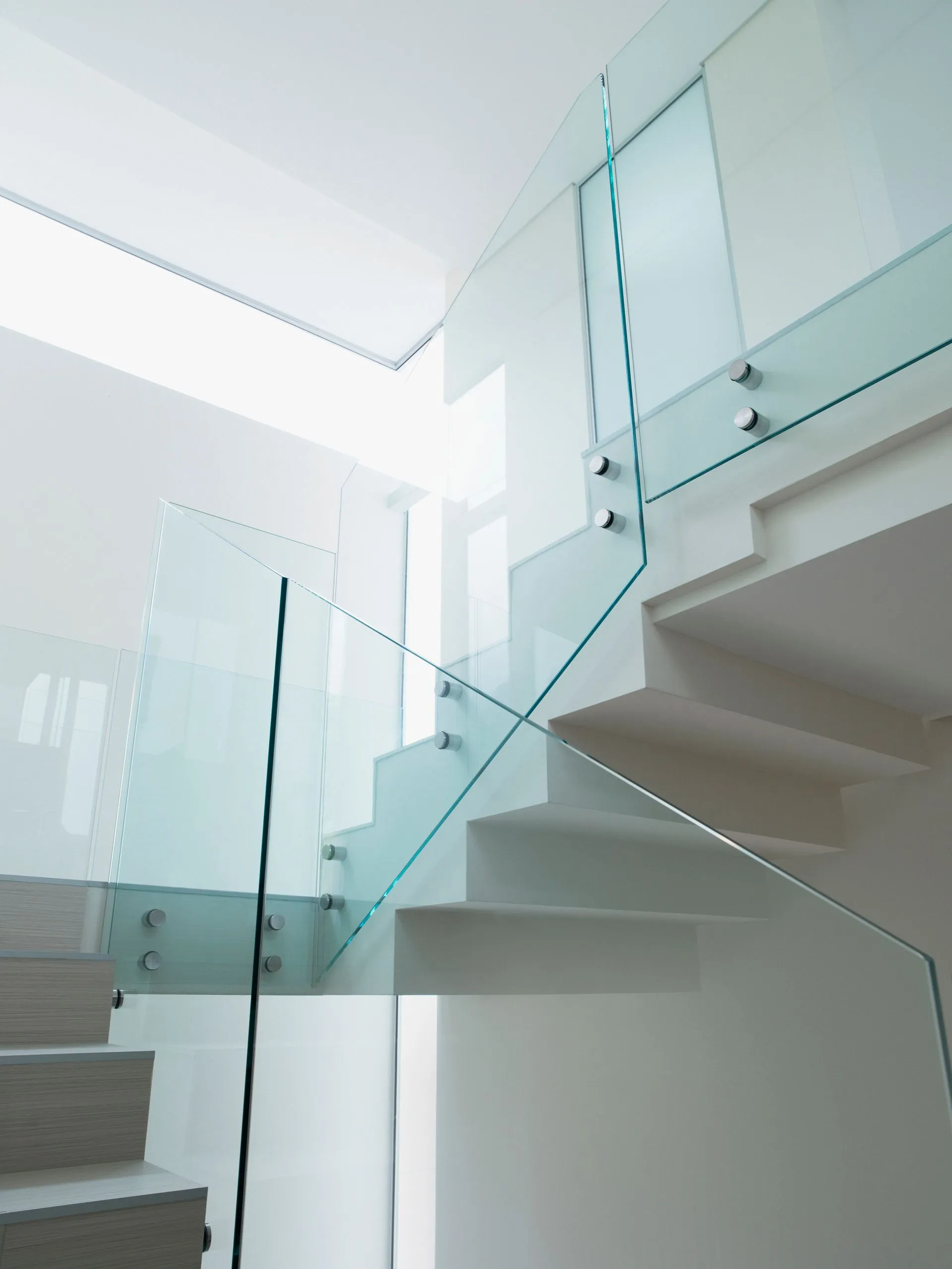 White staircase with glass railing, modern interior design.