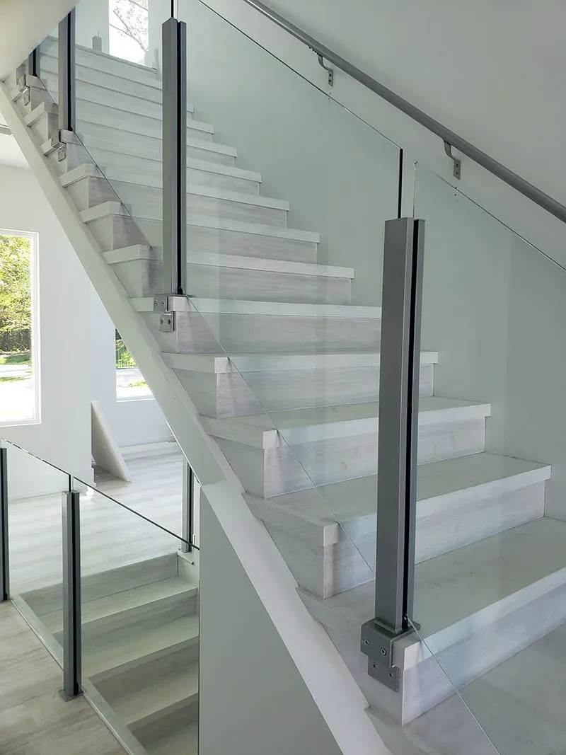 White staircase with glass panels and metal handrails.