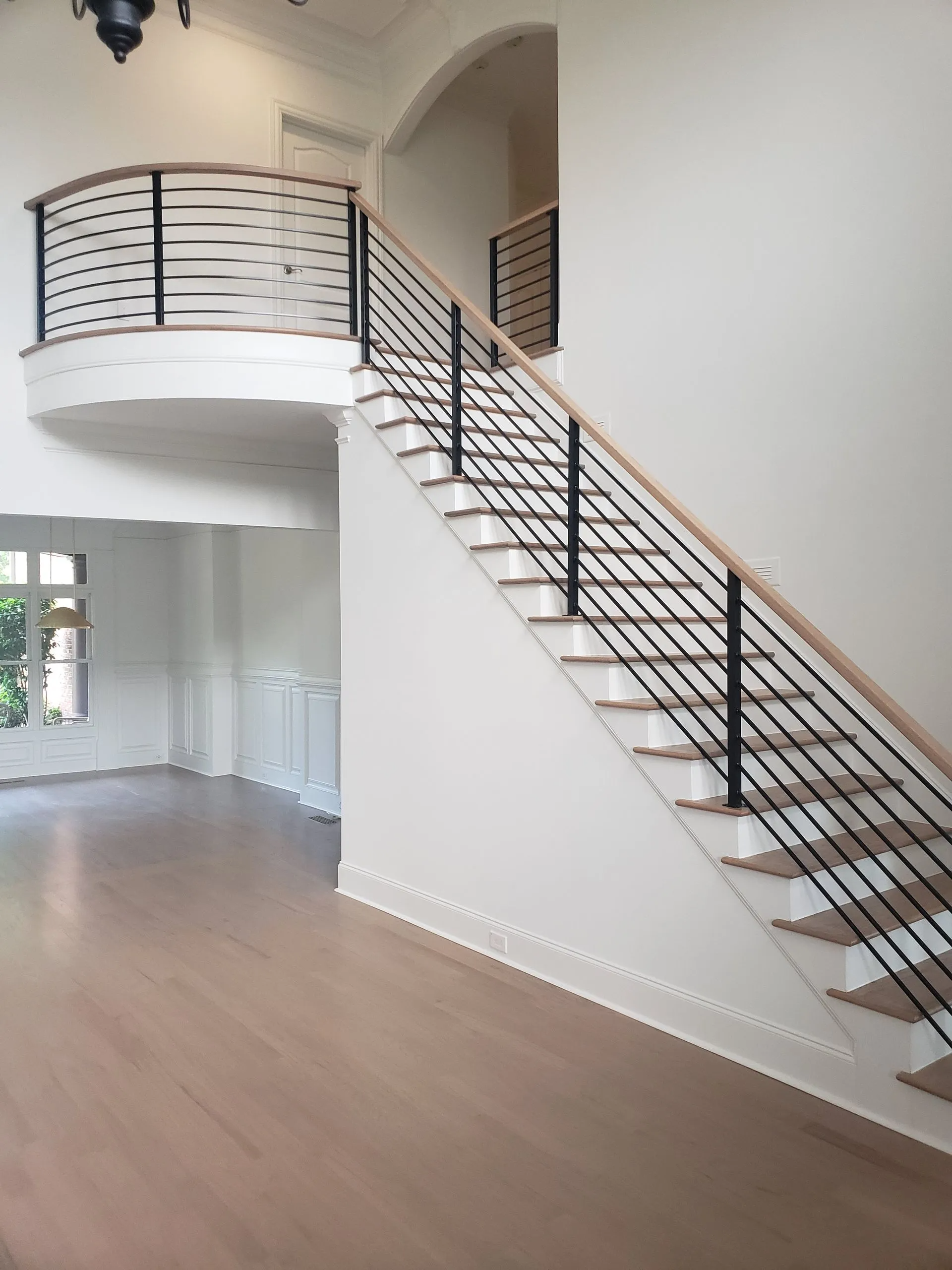Staircase with wooden steps and railing in a bright, modern interior.