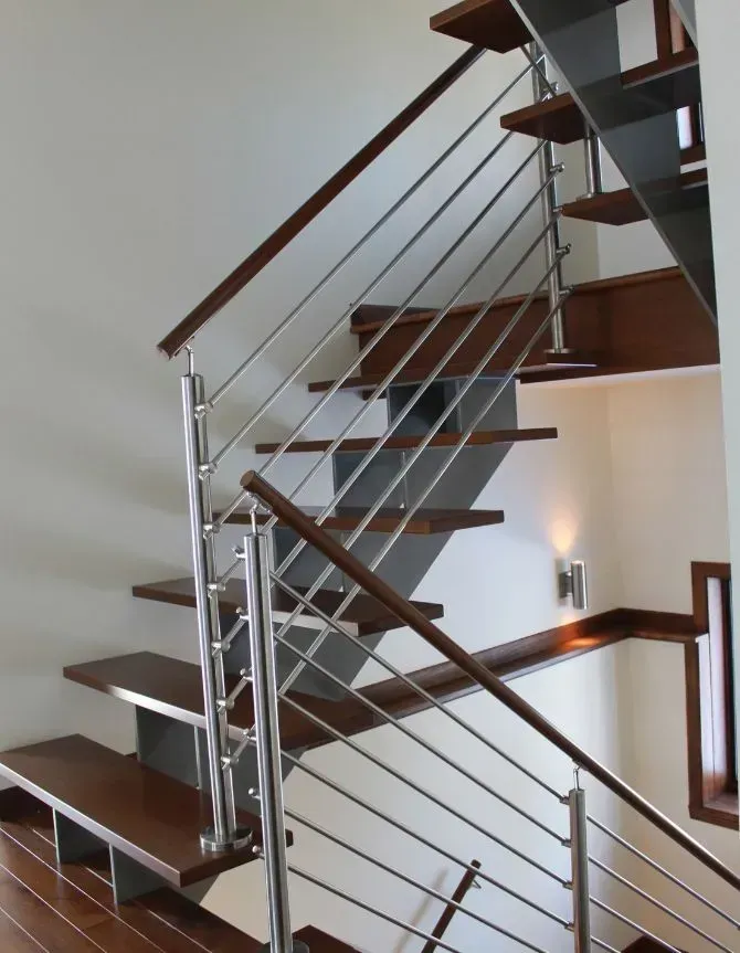 Wooden staircase with stainless steel handrails and horizontal bars.