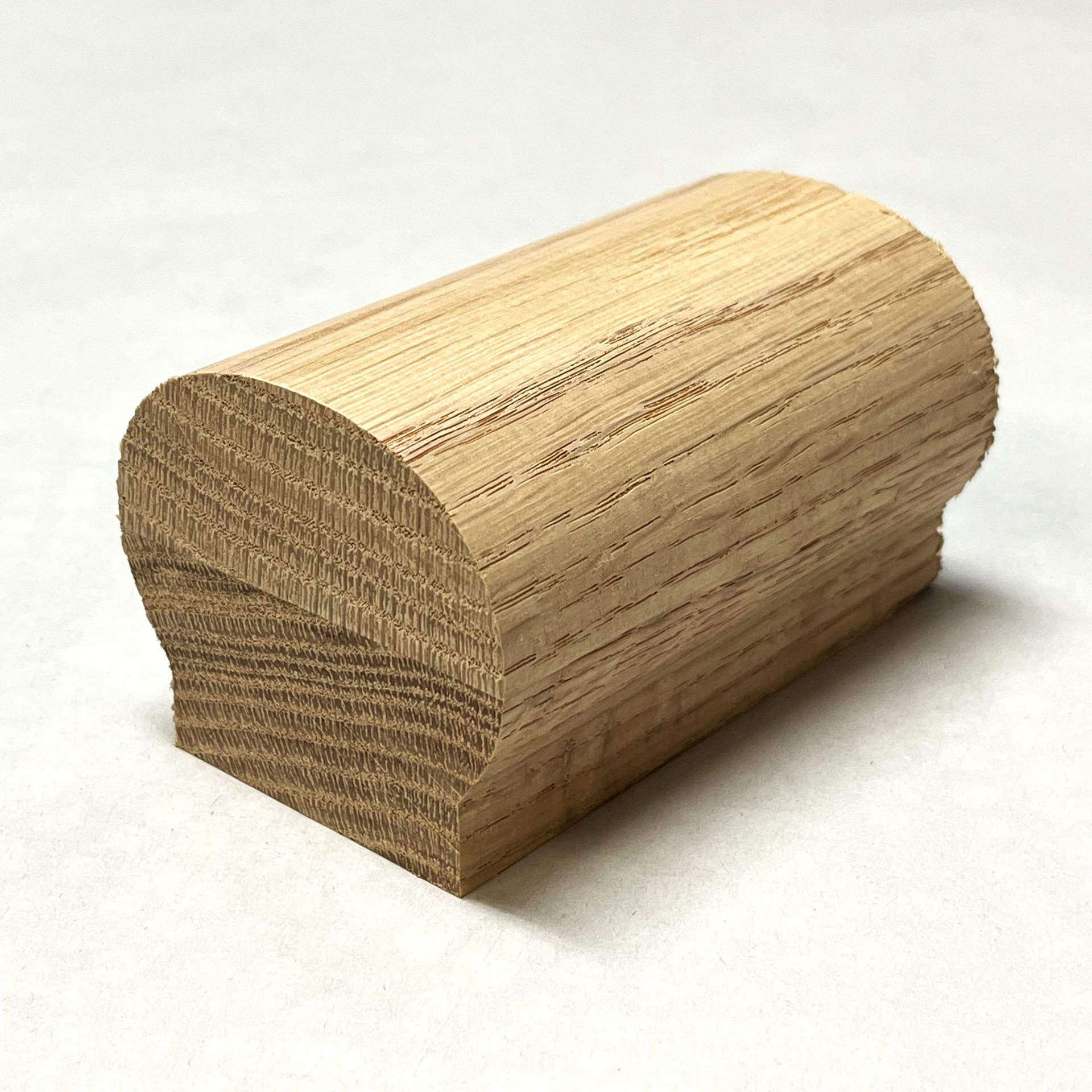 Wooden handrail with a rounded top and flat bottom.