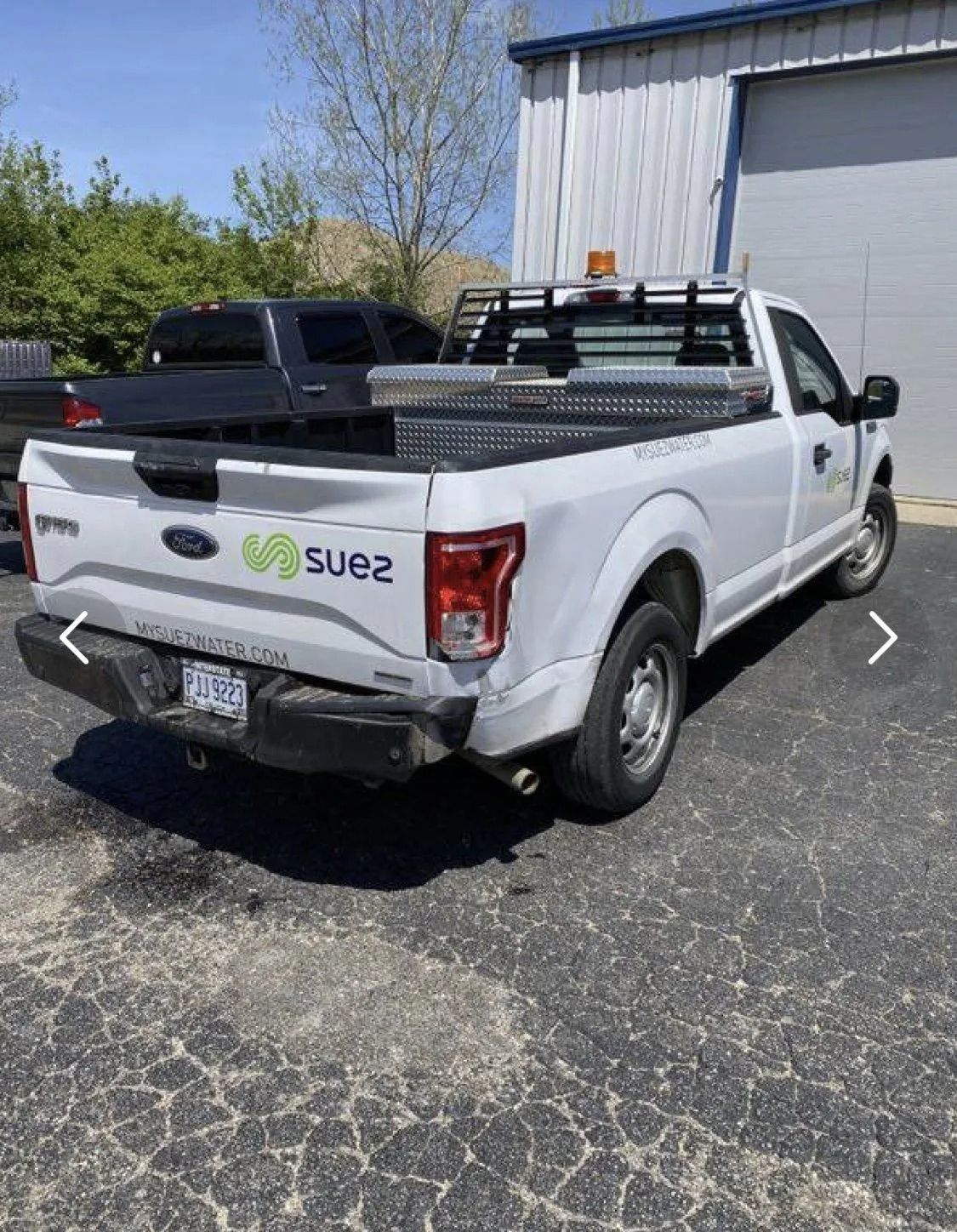 A white truck is parked in front of a building.
