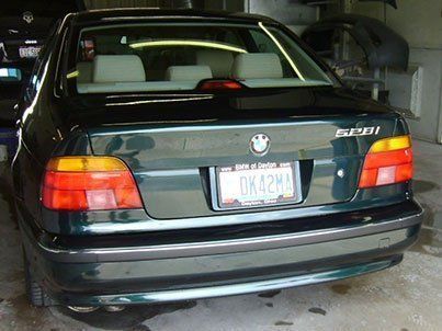 A green bmw is parked in a garage