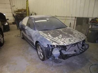 A car is being painted in a garage.