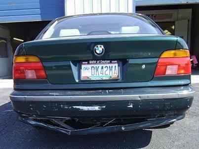 A green bmw with a license plate that says ok42ma