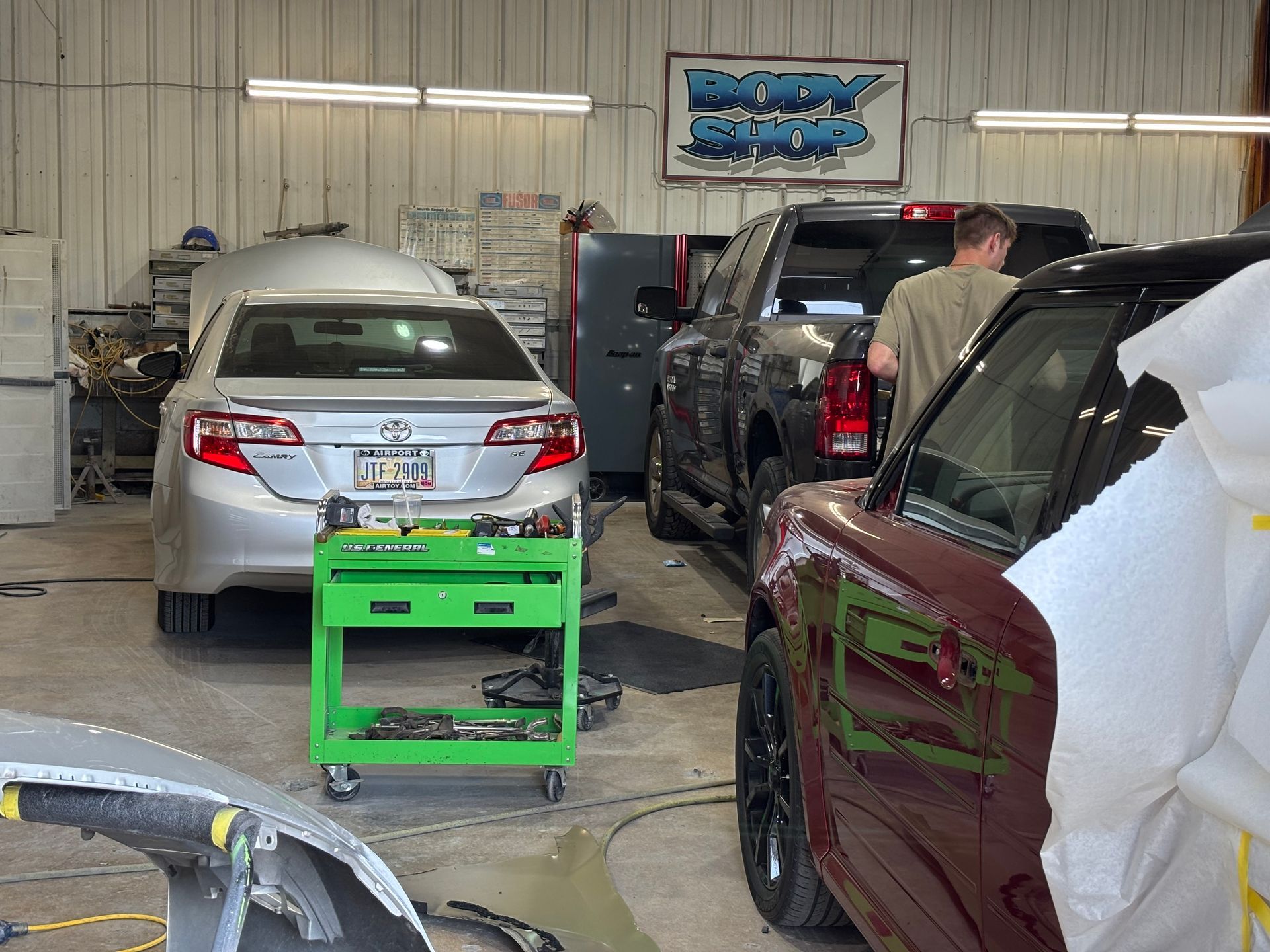 A man is working on a truck in a garage.