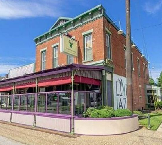 A brick building with a purple awning and a sign that says liv ia7