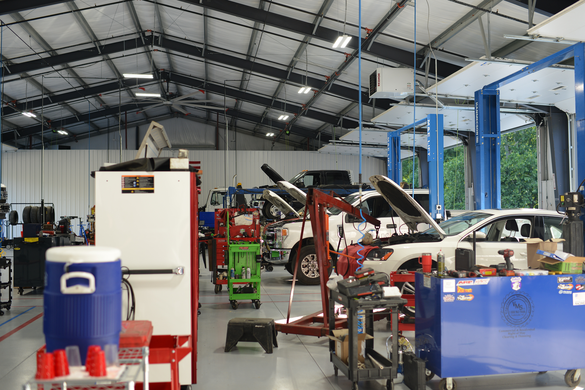 Auto repair shop with cars on lifts and workshop equipment inside a large industrial garage