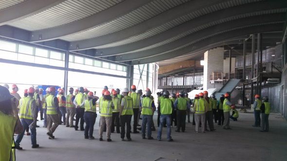 A group of construction workers are standing in a large building