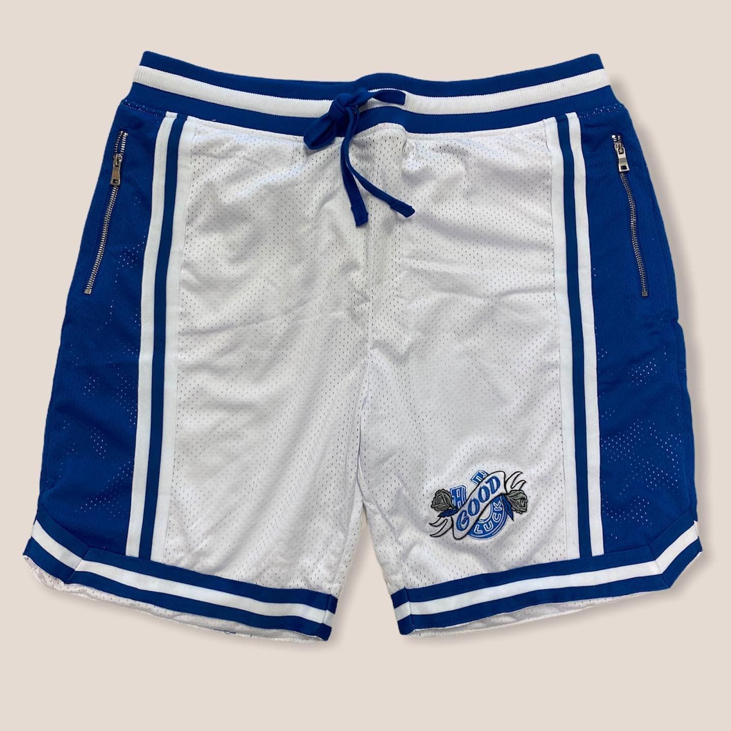 Blue and white athletic shorts with drawstring and side stripes, laid flat on a light background