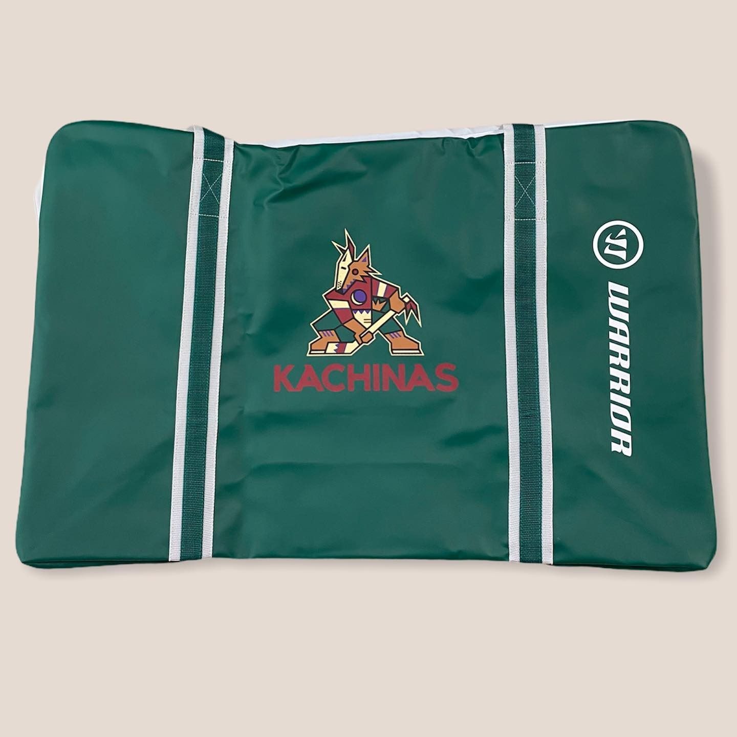 Green Kachinas-branded duffel bag with white stripes and embroidered logo, shown closed on a plain background