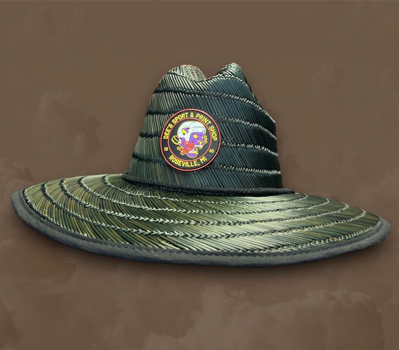 Green woven wide-brim hat with a colorful circular emblem on the front.