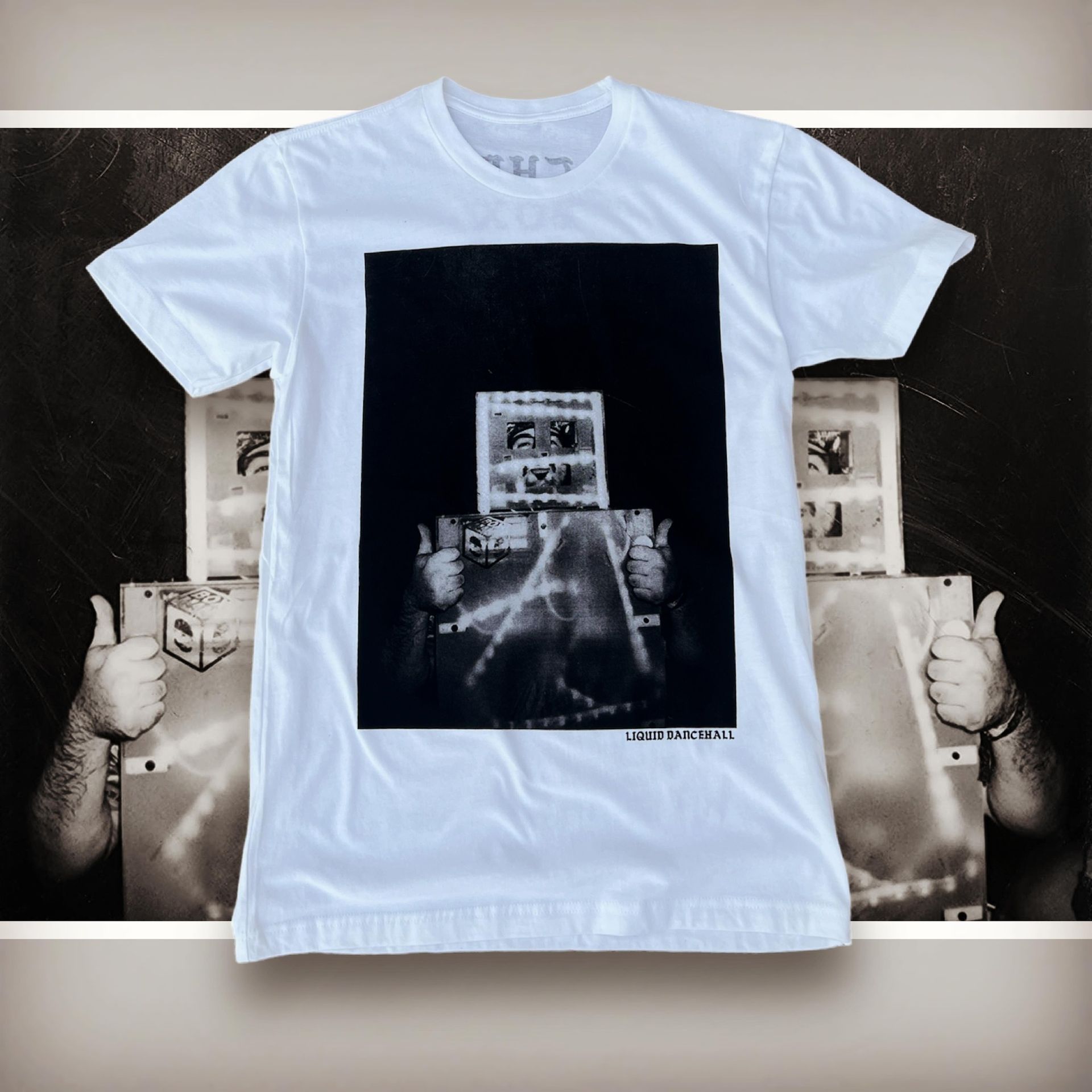 White T-shirt with a black rectangular graphic of a concert stage and crowd, displayed on a poster backdrop