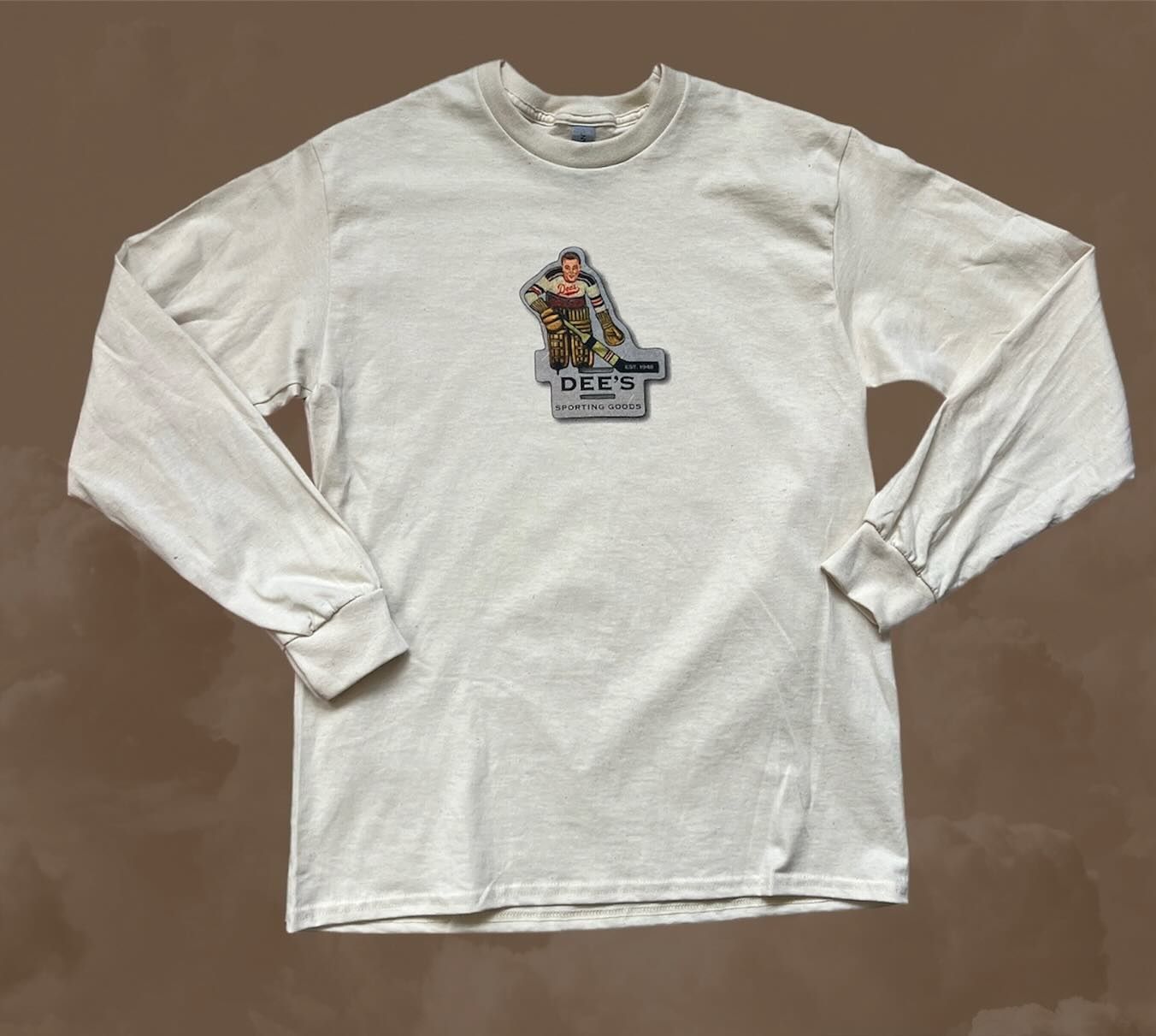 White long-sleeve shirt with a small graphic logo centered on the chest.