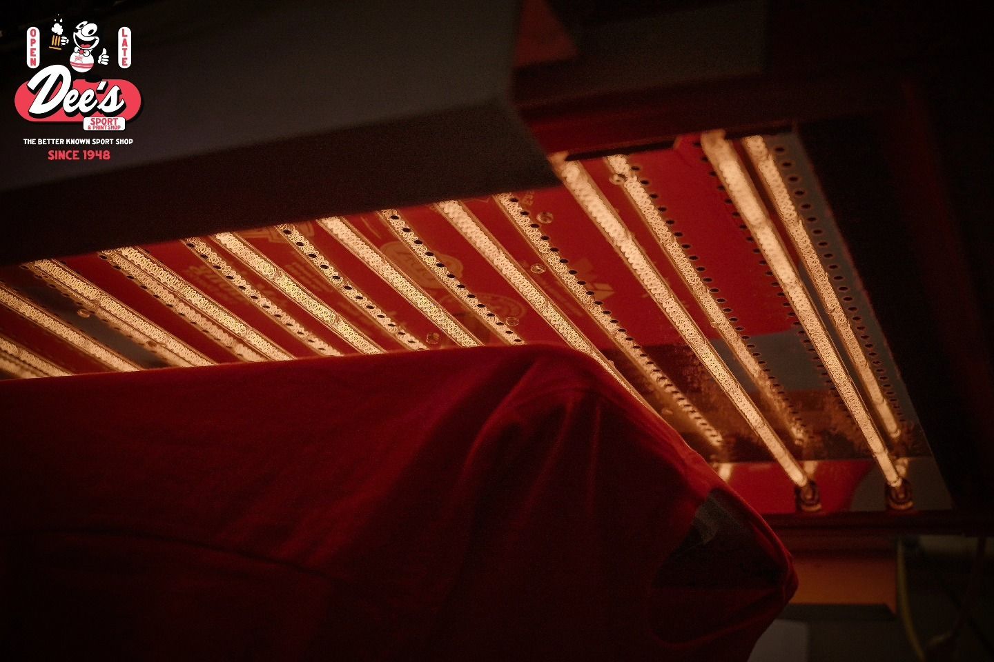 Red car under a red-and-white striped awning at night
