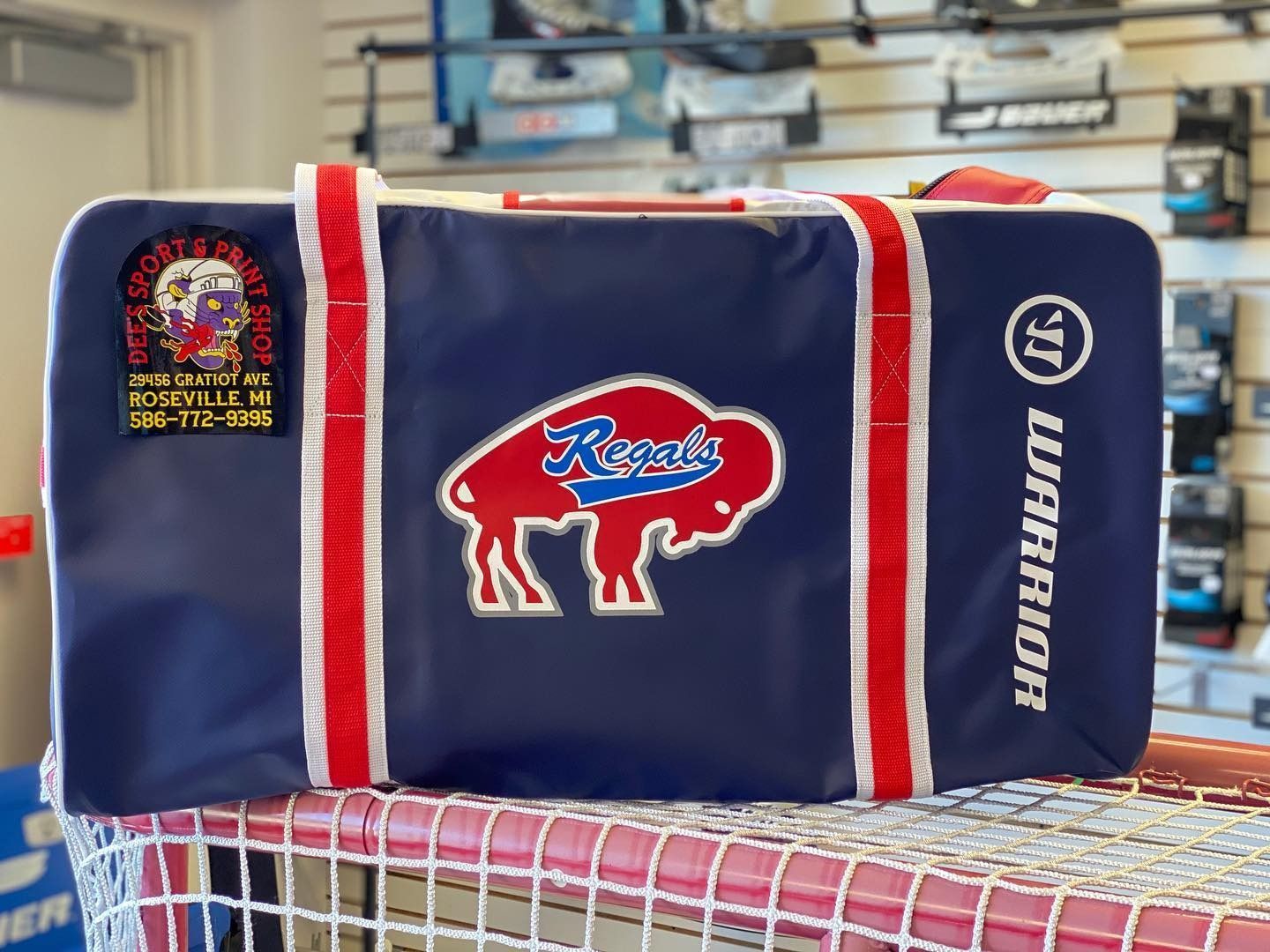 Blue Buffalo Bills duffel bag with red and white trim on a shelf, showing team logos.