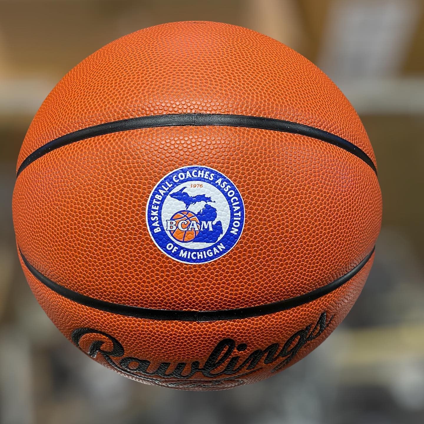 Orange basketball with a blue circular logo and the word “Rawlings” on it