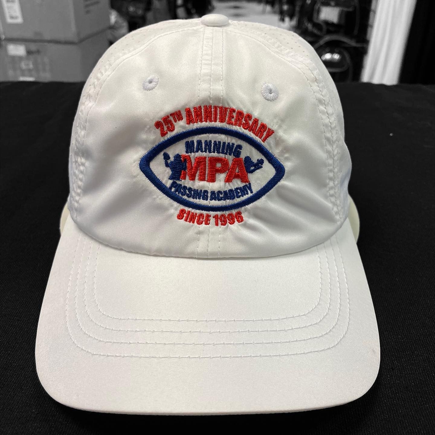 White baseball cap with red and blue “MIPA” embroidery on the front.