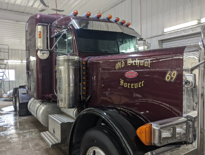 Maroon semi truck with chrome details parked indoors, labeled “Old school forever 69”