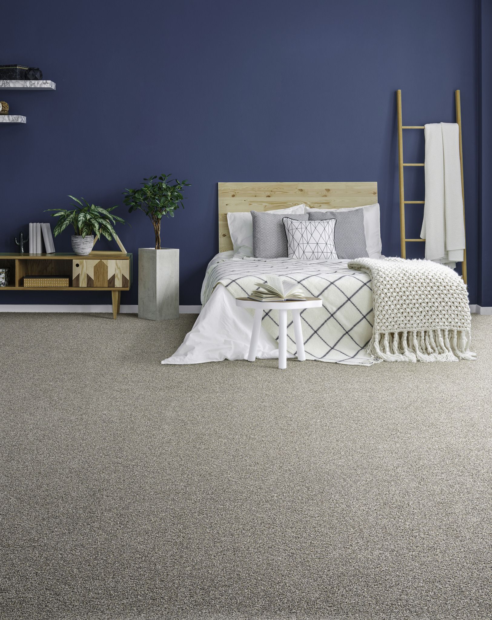 a bedroom with a bed, nightstand, carpet and blue walls