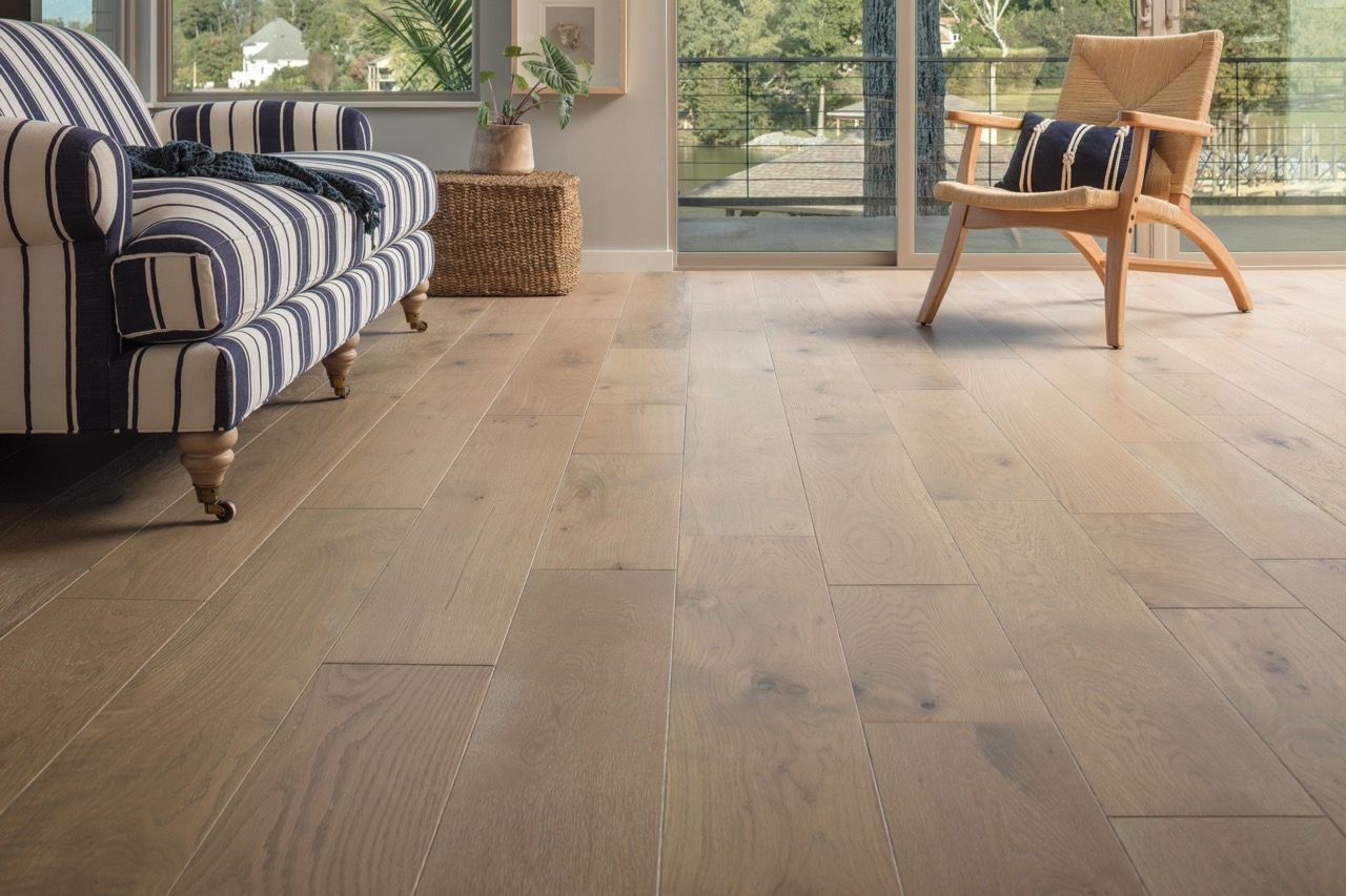 a living room with hardwood floors, a couch and a chair