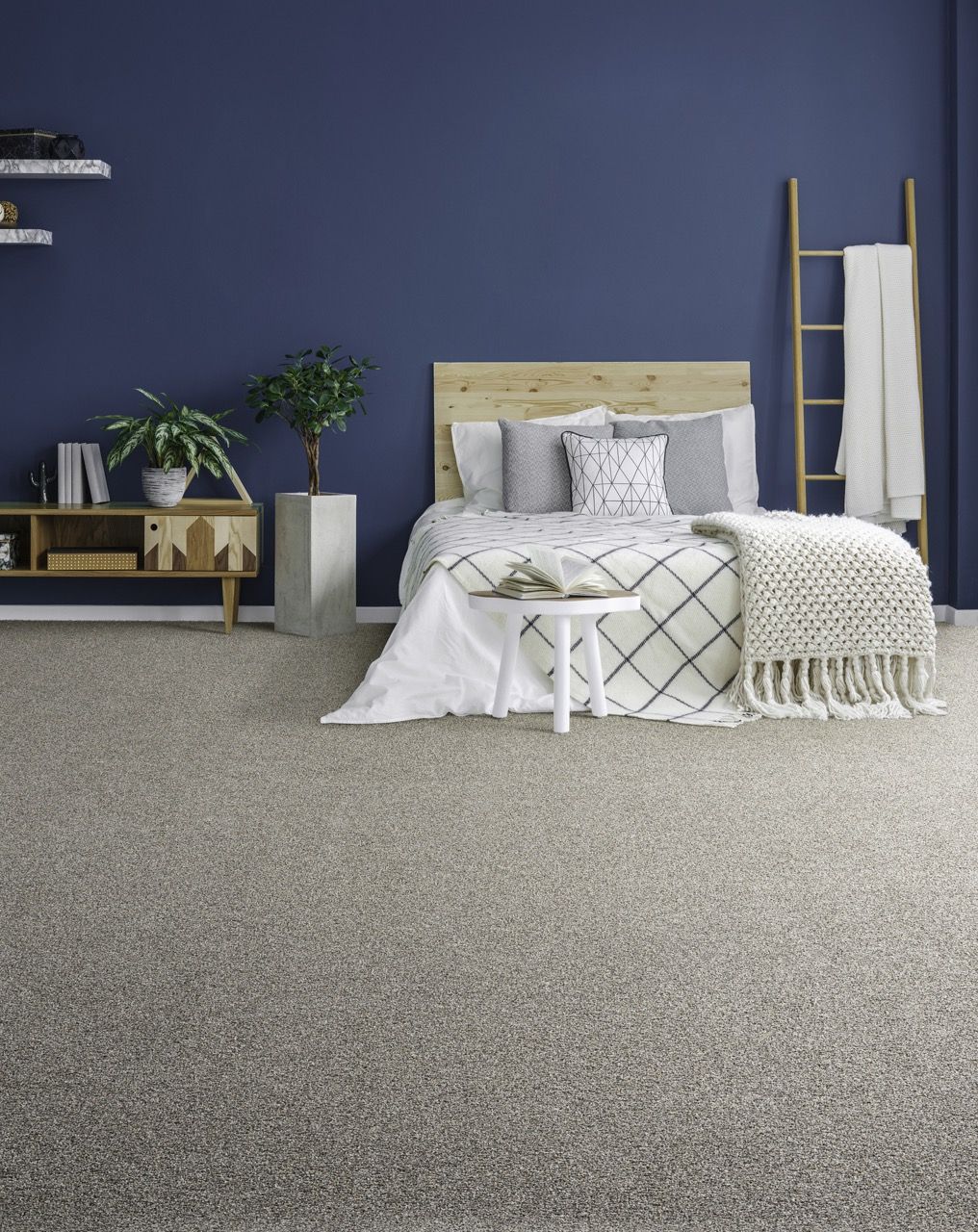 a bedroom with a bed, nightstand, carpet and blue walls