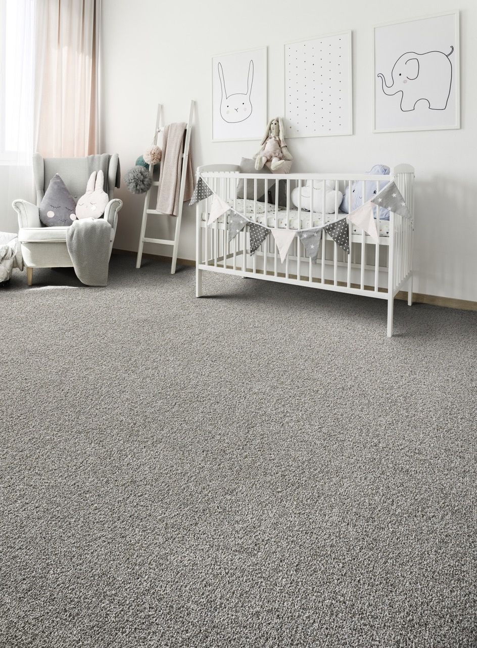 there is a crib in the middle of the room with a gray carpet