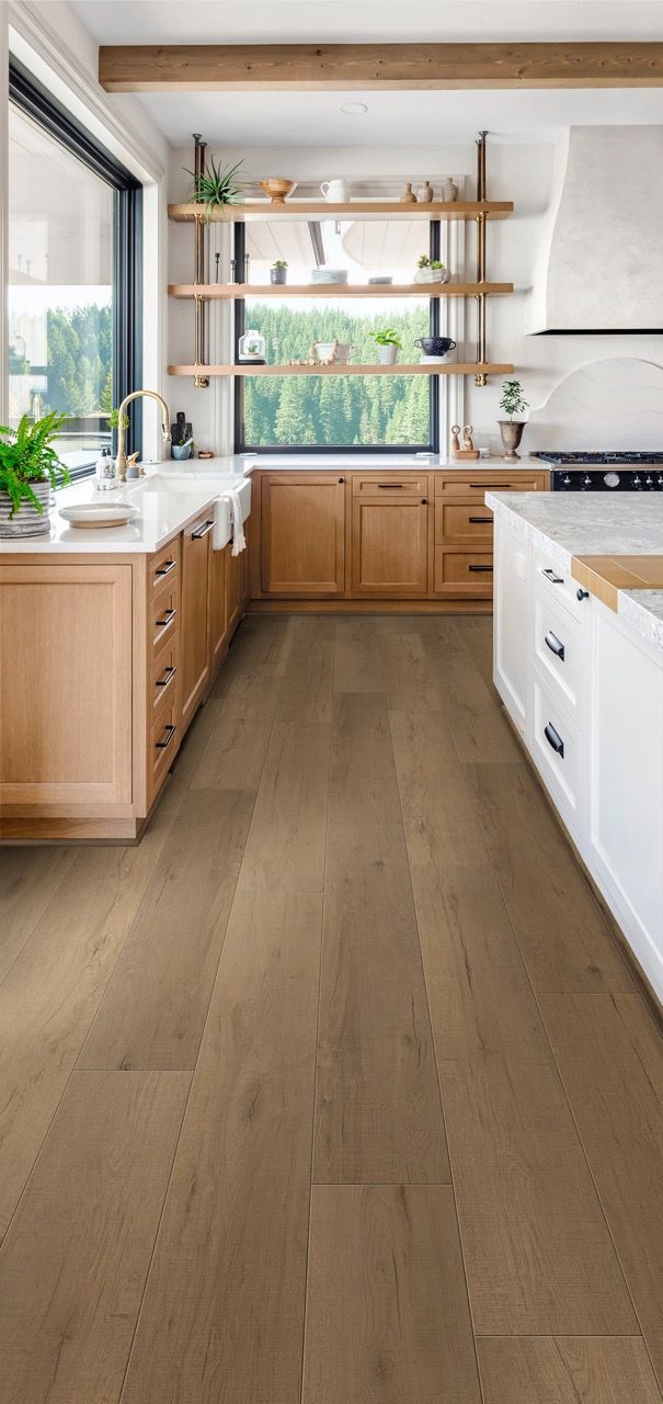 a kitchen with hardwood floors and white cabinets
