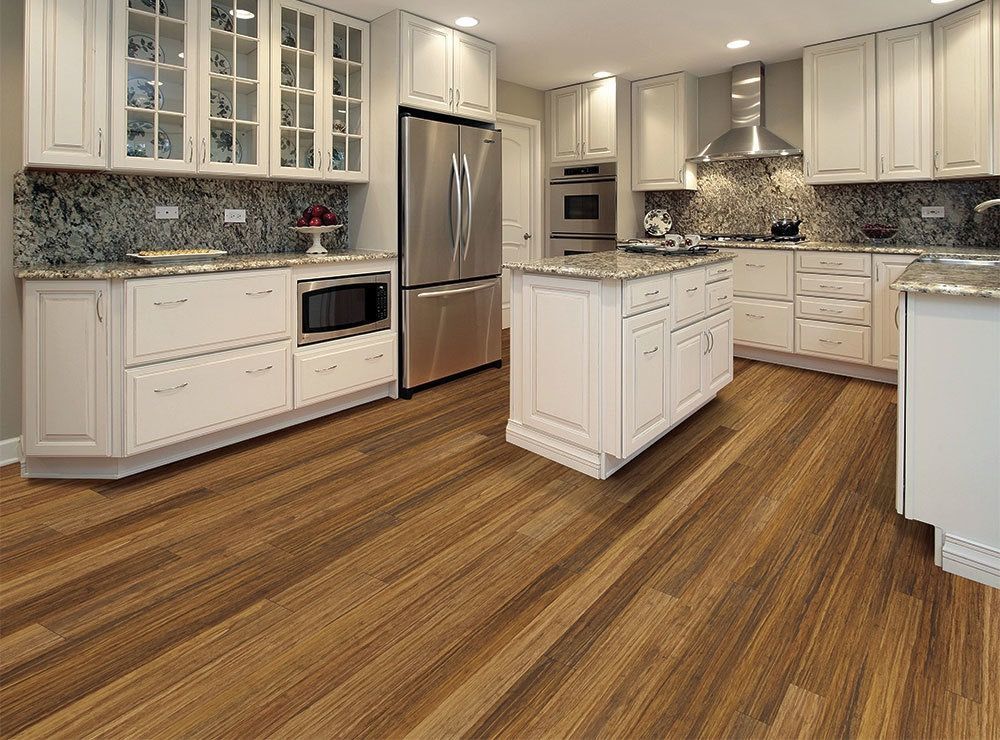 a kitchen with white cabinets and wooden floors