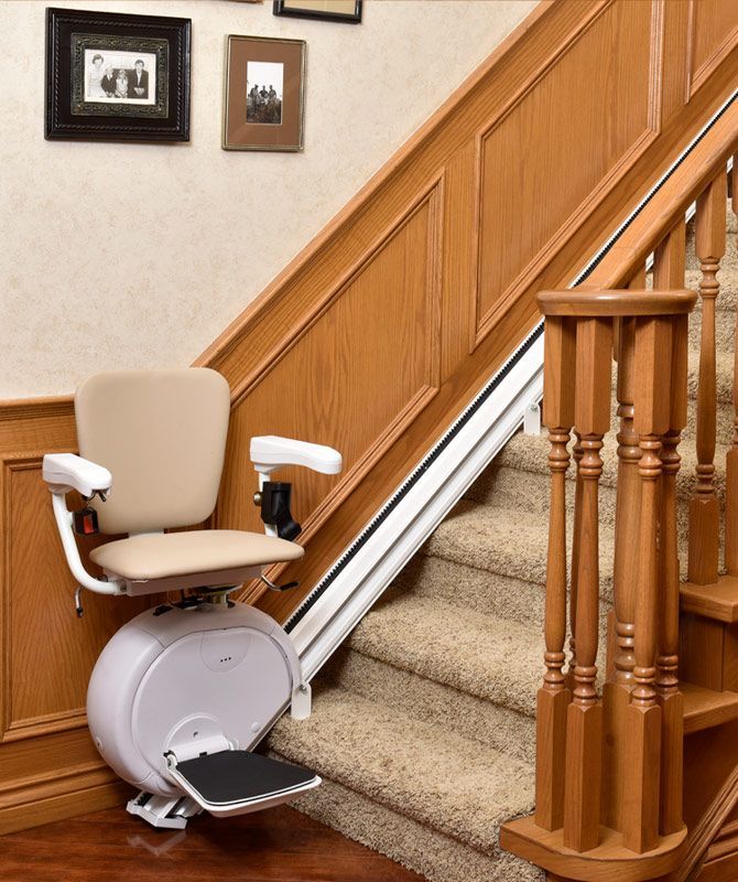 A stair lift sits on the bottom of a set of stairs