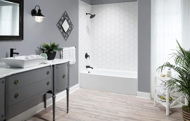 A bathroom remodeling with sink, mirror, tub, and shower.