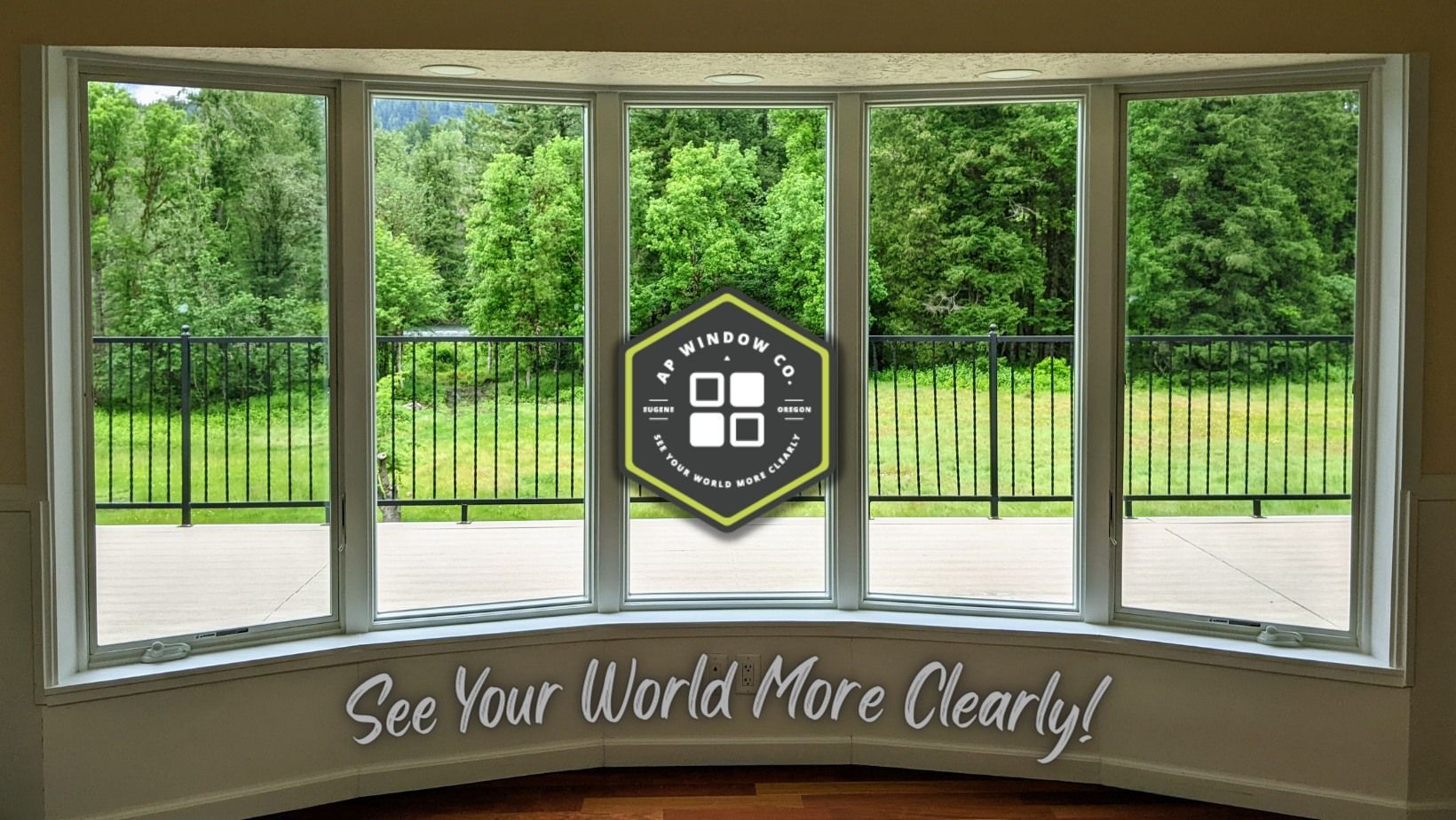 Bay window overlooking a green landscape with a black railing. The text says 