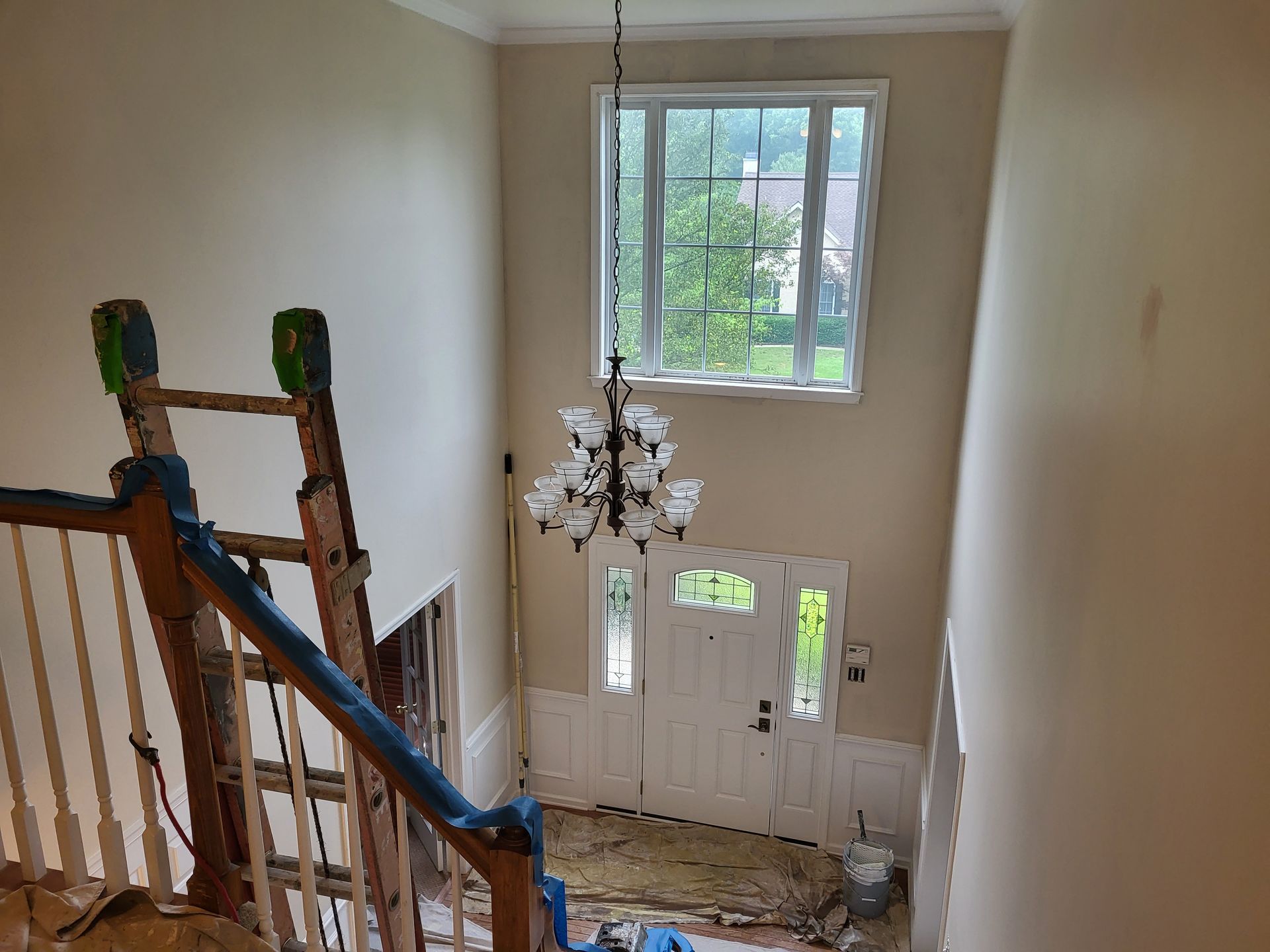 An aerial view of a staircase in a house being painted.
