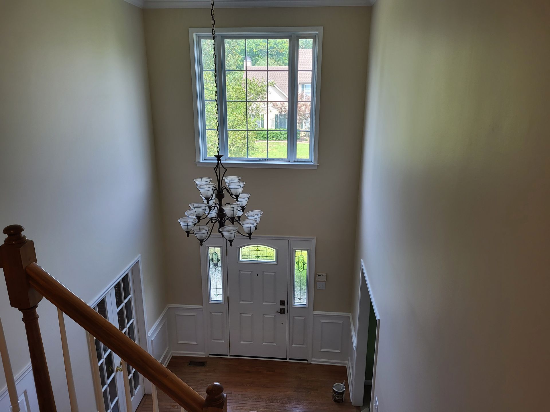 A staircase leading up to a door with a chandelier hanging from the ceiling.
