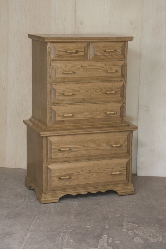 Two wooden chests of drawers are stacked on top of each other.