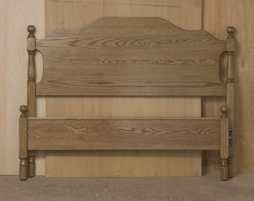 A wooden headboard is sitting in front of a wooden wall