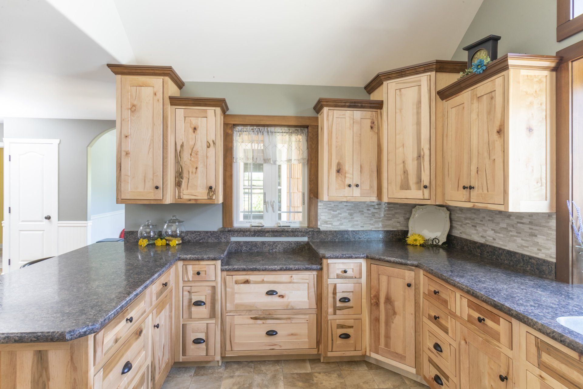 A kitchen with wooden cabinets and granite counter tops.