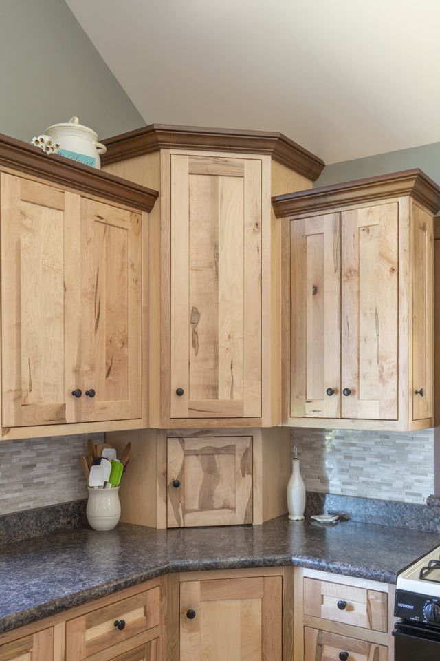 A kitchen with wooden cabinets and granite counter tops.