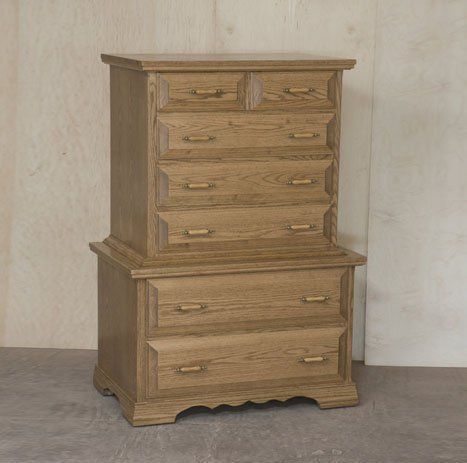 Two wooden chests of drawers are stacked on top of each other.