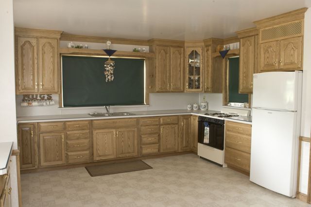 A kitchen with wooden cabinets and a white refrigerator