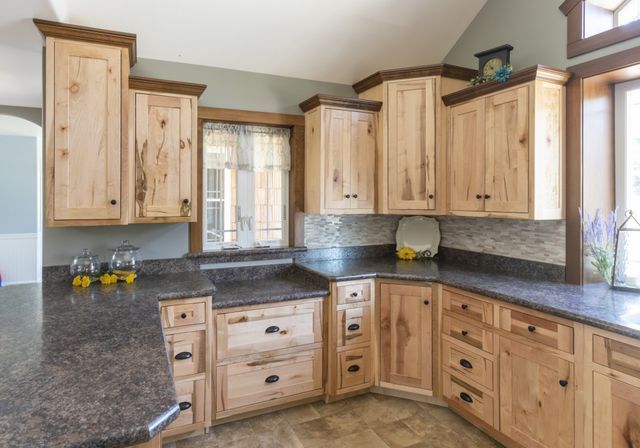 A kitchen with wooden cabinets and granite counter tops.