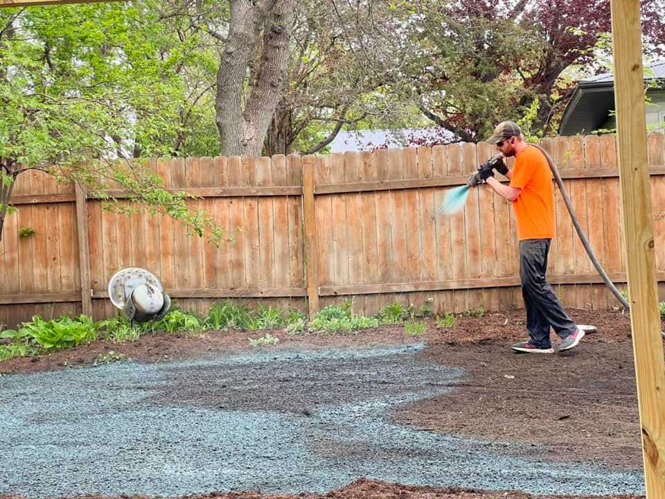 A man is spraying a lawn with a hose.